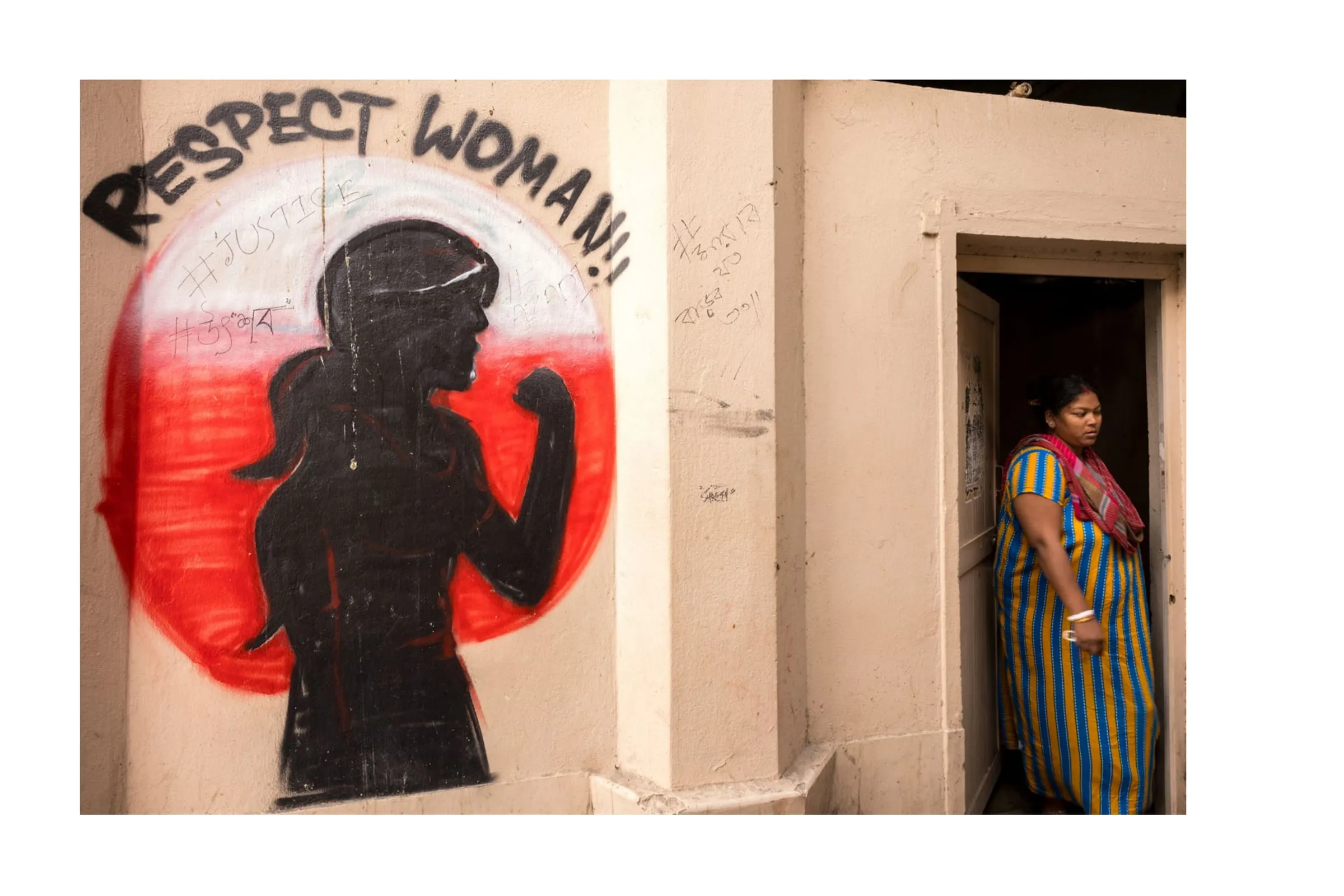 Wandbild „Protect Women" neben einem Hauseingang