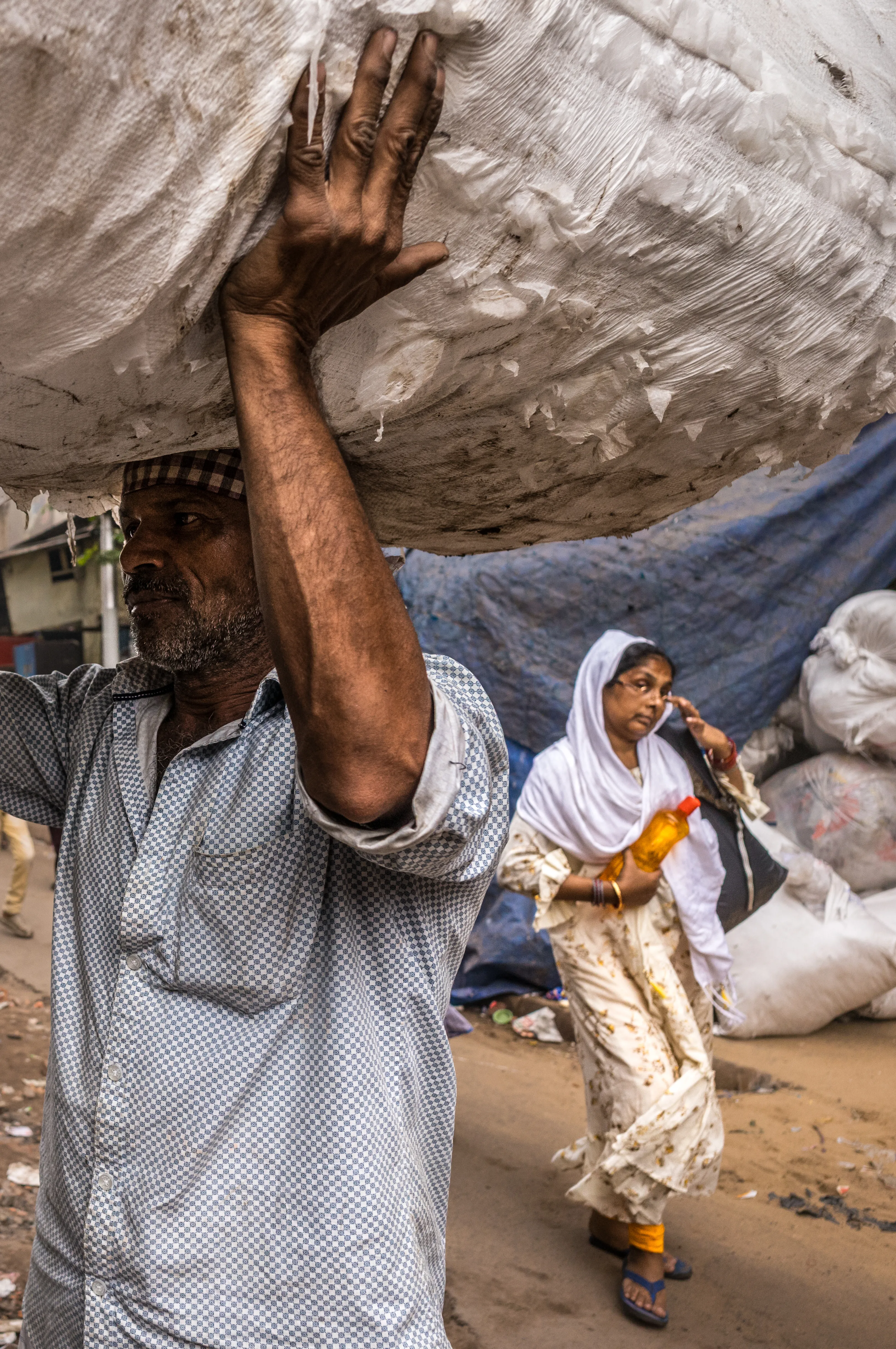 Mann trägt Recyclingballen durch eine Gasse in Kolkata — Andrea Evers